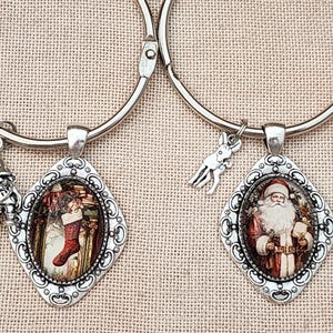 Può includere: Due portachiavi in metallo color argento, ciascuno con un ciondolo a forma di diamante con cabochon in vetro. Un ciondolo mostra una calza natalizia, l'altro una figura di Babbo Natale. Ogni anello include un piccolo ciondolo, uno gnomo e un cervo.
