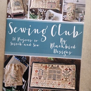 Puede incluir: Un libro titulado "Sewing Club" de Blackbird Designs con 16 proyectos para bordar y coser. La portada presenta una variedad de proyectos de punto de aguja, incluyendo una almohada, un alfiletero y una pequeña bolsa.