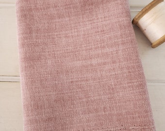 May include: A piece of pink fabric with a textured surface. The fabric has a raw edge and is folded in half.