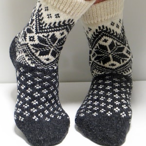 May include: Pair of black and white knitted socks with a geometric pattern. The socks are made of wool and have a comfortable fit.