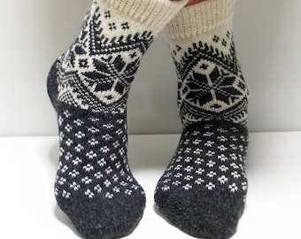 Könnte beinhalten: Paar schwarze und weiße Stricksocken mit geometrischem Muster. Die Socken sind aus Wolle und haben eine bequeme Passform.