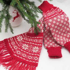 May include: Red and white knitted leg warmers with a traditional Scandinavian snowflake pattern. The leg warmers have a fringed edge.