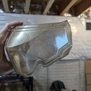 Könnte beinhalten: Ein transparenter, durchsichtiger Plastikhelm mit geometrischem Design. Der Helm hat eine glatte, glänzende Oberfläche und scheint aus einem strapazierfähigen Material hergestellt zu sein.