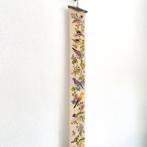 May include: A white ceramic mug with a black handle and the text "But First, Coffee" in a black, bold font. The mug is on a white surface. The mug is approximately 10 cm tall.