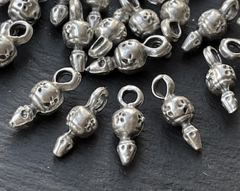 May include: A collection of small, silver-toned metal charms, each featuring a spherical body with a floral-like pattern of small indentations, a pointed bottom tip, and a circular loop at the top for attachment to jewelry or other craft projects.
