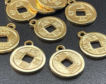 May include: A collection of gold-colored Chinese lucky coin charms with a square hole in the center and Chinese characters around the edge.