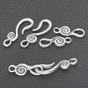 May include: A collection of silver-toned metal jewelry clasps featuring a decorative spiral design. The set includes several hook-and-eye style components, with some pieces shown separated and one pair connected together to demonstrate the mechanism.