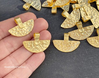 May include: A group of gold-toned metal pendant charms with a hammered texture. The charms are shaped like half circles with a loop at the top for attaching to a chain or cord.