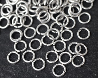 May include: A close-up of a pile of silver jump rings. The rings are small and round, and they are perfect for jewelry making.