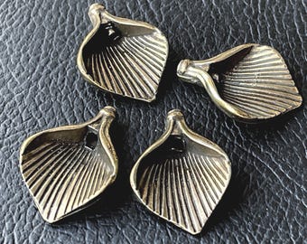 May include: Four metallic, antique-bronze colored pendants shaped like calla lily flowers. Each piece features a flared, petal-like form with deep, vertical ridges radiating from a central point, and a small loop at the top for attachment.