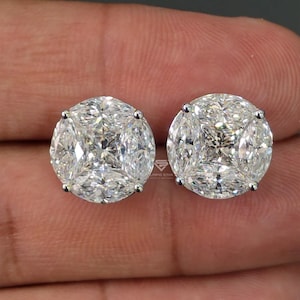 May include: A pair of round stud earrings featuring a cluster of marquise-cut clear stones arranged in a circular pattern. Each earring is set in a silver-toned metal frame with four prongs securing the stones, creating a brilliant, faceted appearance.