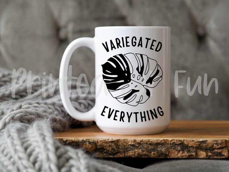 May include: White ceramic mug with a black and white illustration of a monstera leaf and the text "VARIEGATED EVERYTHING".
