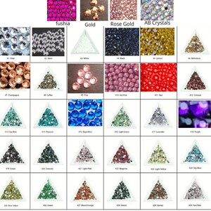May include: A chart of 30 different colors of rhinestones, each color is displayed in a small triangle-shaped container. The colors include clear, silver, white, black, lemon, champagne, coffee, pink, hot pink, red, crimson, sea blue, peacock, royal blue, light green, lavender, purple, grape, emerald, light pink, magenta, light yellow, sky blue, olive yellow, green, blood orange, denim, garnet, and pale pink.