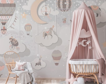 Könnte beinhalten: Ein Kinderzimmer mit einer verspielten Tapete mit Heißluftballons, Wolken und Zirkustieren. Ein rosa Baldachin hängt über einer Wiege aus Korbgeflecht. Ein Holzstuhl mit Kissen und Decke steht daneben und schafft einen fantasievollen Raum.