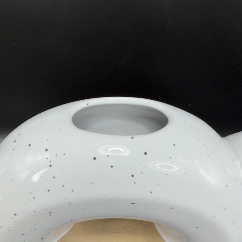Peut inclure: Un vase en c&eacute;ramique blanc avec un motif tachet&eacute;. Le vase a une forme arrondie avec une grande ouverture en haut. L'int&eacute;rieur du vase est de couleur beige clair.