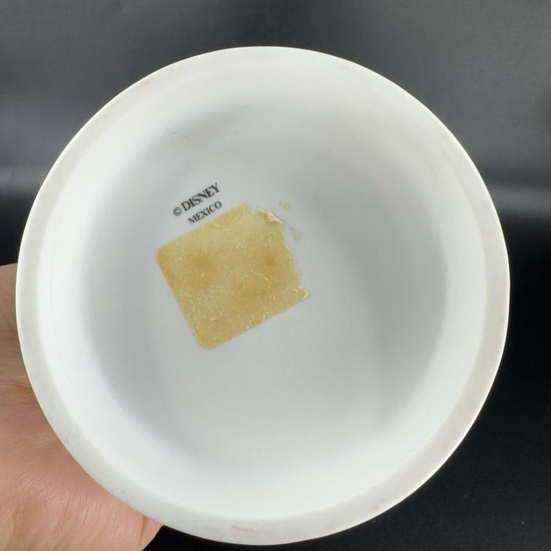 May include: White ceramic base with a sticker that says "&copy; DISNEY MEXICO" on the bottom.