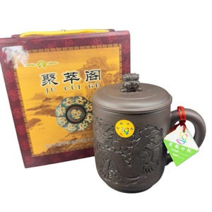 May include: A brown ceramic mug with a lid, handle, and dragon relief design. The mug is accompanied by a box with Chinese characters and a yellow handle. A small tag is attached to the handle.