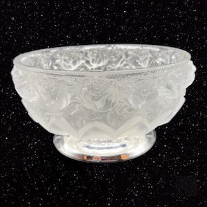 May include: A frosted glass bowl with a silver base. The bowl is decorated with a raised design of roses.