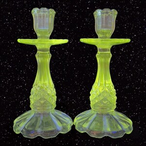 May include: A pair of vintage yellow glass candle holders with a diamond pattern. The candle holders are made of uranium glass and glow under a black light.
