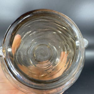 May include: A clear glass jar with a textured surface and a wide opening. The jar has a silver rim and two silver handles.