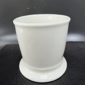 May include: A set of three ceramic mugs with a speckled, matte finish. The mugs are in shades of cream, light gray, and dark gray. Each mug has a simple, minimalist design, perfect for coffee or tea.