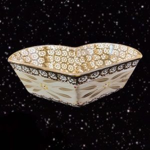 May include: A heart-shaped ceramic serving bowl with a brown and white floral pattern. The bowl has a scalloped edge and a glossy finish.