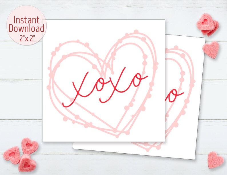 Puede incluir: Dos tarjetas cuadradas blancas con un dise&ntilde;o de coraz&oacute;n rosa y el texto rojo "xoxo". El coraz&oacute;n est&aacute; delineado con una l&iacute;nea punteada. Las tarjetas miden 5,08 cm x 5,08 cm y est&aacute;n etiquetadas como "Descarga instant&aacute;nea". Caramelos rosas en forma de coraz&oacute;n en el fondo.