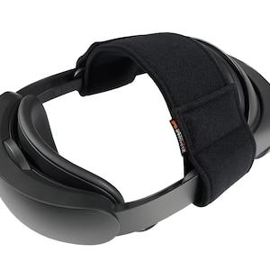 May include: Black VR headset with a black adjustable strap. The strap has the word "GRAVITY" printed on it in orange.
