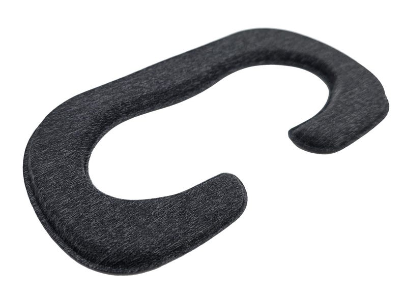 May include: A dark gray, curved VR headset facial interface replacement. The accessory is made of a soft, textured material and is designed to fit around the eyes and nose for comfort during virtual reality use.