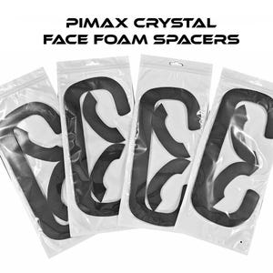 May include: Four black foam face spacers in clear plastic packaging. The text "PIMAX CRYSTAL FACE FOAM SPACERS" is printed in black above the packages. The spacers are curved and designed to fit a VR headset.