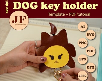 May include: A brown and yellow dog-shaped key holder with a heart-shaped key ring. The key holder is made of leather and has a cute cartoon face. The image includes the text "DOG key holder" and "Template + PDF tutorial".