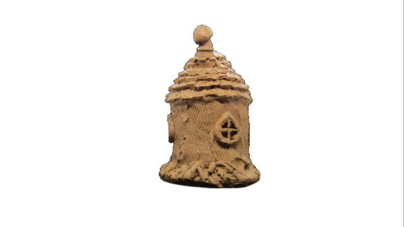 May include: A small, brown, ceramic fairy house with a pointed roof and a window. The house is decorated with a textured surface that resembles bark.