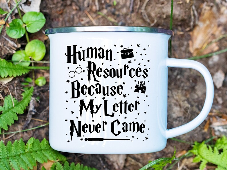 May include: White enamel mug with a black graphic that reads "Human Resources Because My Letter Never Came." The graphic includes a briefcase, glasses, a lightning bolt, a castle, and a wand.