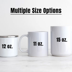 Op de afbeelding: Drie witte mokken in verschillende maten. De mokken zijn gelabeld met hun capaciteit: 12 oz, 11 oz en 15 oz.