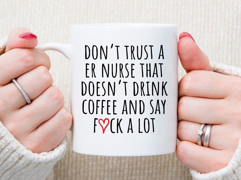 May include: White ceramic coffee mug with black text that reads "Don't trust a ER nurse that doesn't drink coffee and say &hearts;ck a lot".