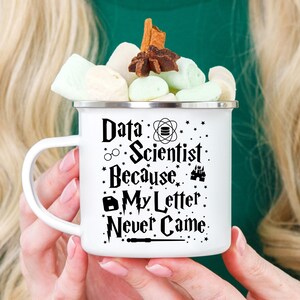 May include: White enamel mug with a black design that says "Data Scientist Because My Letter Never Came" with a wand, glasses, and other Harry Potter themed graphics.