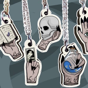 Colliers en forme de mains de sorcières - pendentif en bois  - Main de sorcière - Crâne / Potion magique / Grimoire / Carte / Œil