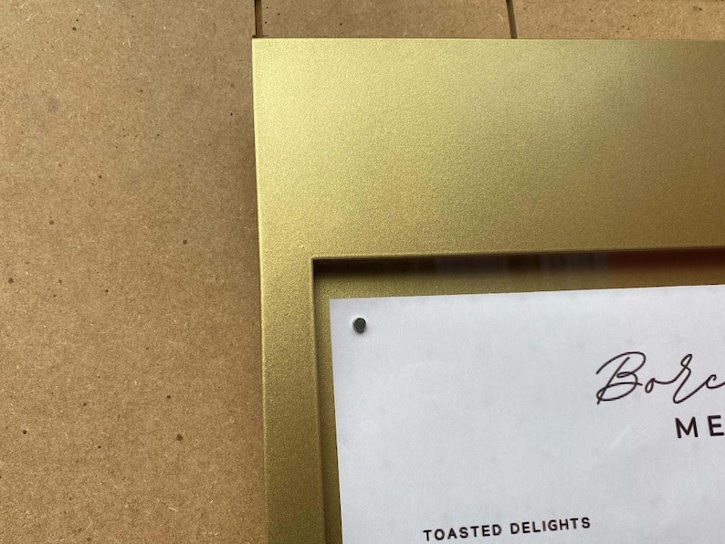 Close-up of the magnetic surface inside the display box, holding A3 paper menu with included magnets