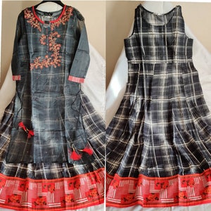May include: Two black and white plaid dresses with red and white trim. The dress on the left has embroidered details on the bodice.