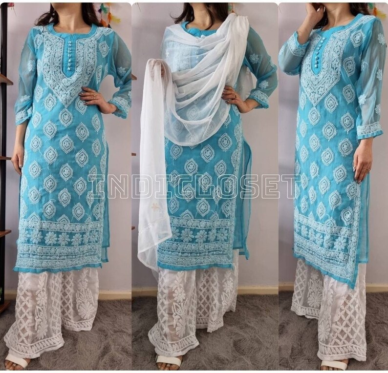 May include: A turquoise blue embroidered kurta with white embroidery and a white dupatta. The kurta has a round neckline and three-quarter sleeves. The dupatta is sheer and has a floral design. The kurta is paired with white palazzo pants with white embroidery.