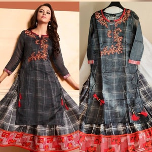 May include: A gray and white plaid long-sleeved dress with red embroidery and a red and white trim. The dress has a long skirt with a layered design.
