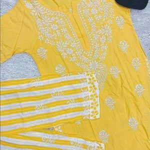May include: A yellow cotton kurta with white embroidery and a matching pair of yellow and white striped pants.