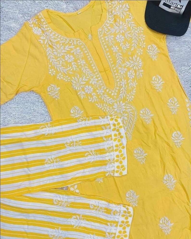 May include: A yellow cotton kurta with white embroidery and a matching pair of yellow and white striped pants.