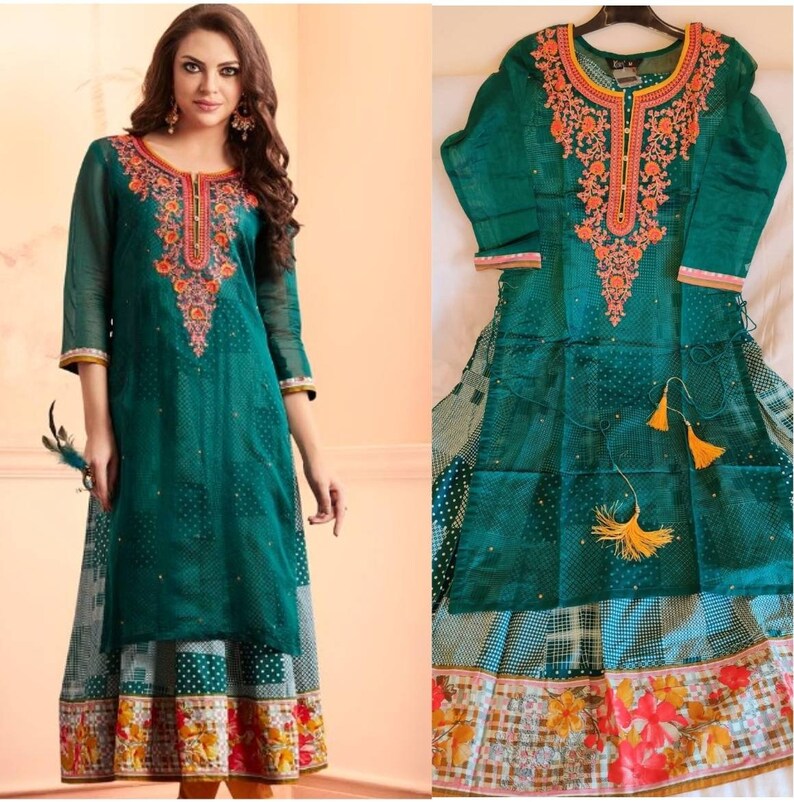 May include: A teal green long-sleeved dress with a floral embroidered neckline and a white and black polka dot skirt. The dress has a sheer overlay with a white and black checkered pattern.