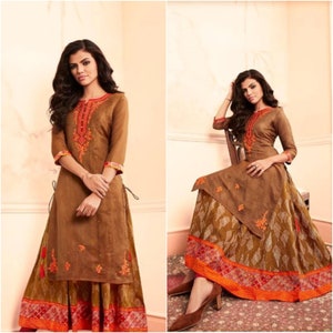 May include: A brown long-sleeved top with embroidery and a matching skirt with a printed pattern. The skirt has a brown, orange, and red border.