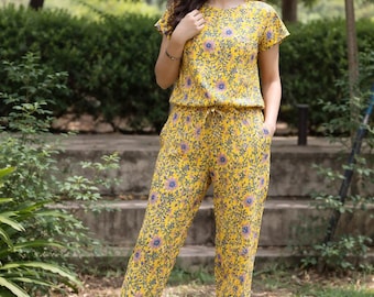 Mono amarillo de algodón con estampado floral y estampado a mano. Conjunto de una pieza de corte relajado, ideal para el verano.