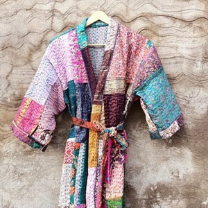 May include: A colourful patchwork robe with a tie belt. The robe is made of a soft, quilted fabric and has a traditional Japanese kimono style.