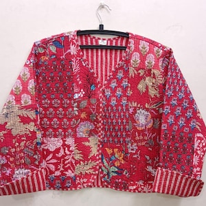 May include: A red quilted jacket with a floral print and a V-neck. The jacket has a striped pattern on the sleeves and a button closure.