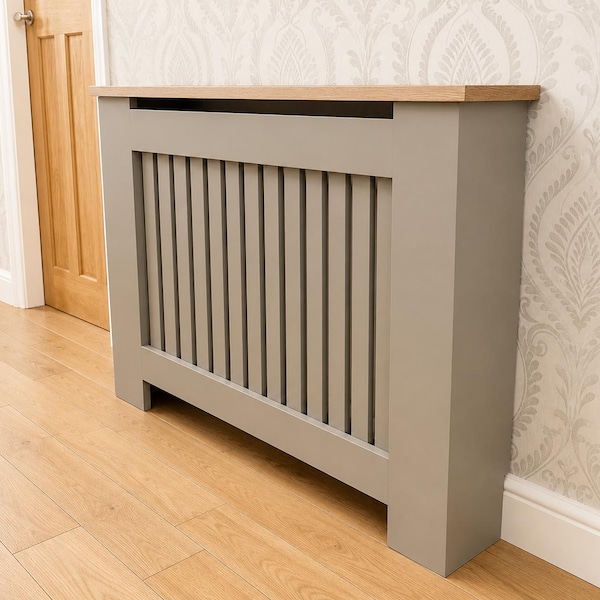 Op de afbeelding: Een rechthoekige radiatorombouw met een matte grijze afwerking, verticale latten aan de voorzijde en een platte, lichtbruine houten bovenplank. De structuur heeft een solide frameontwerp met een open onderkant en een strakke vormgeving.