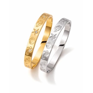 May include: Two bangle bracelets, one gold-toned and one silver-toned, each adorned with sea-themed charms. The charms include starfish, seashells, and seahorses. The gold bracelet has small, clear gemstones. The bracelets are displayed on a white background.